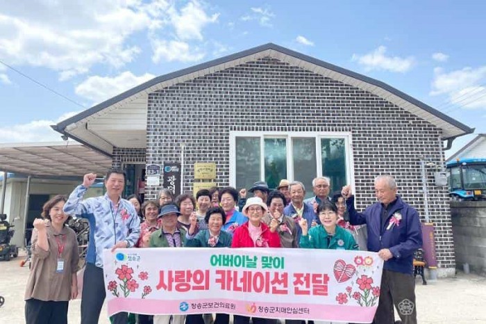 250514보도자료(청송군치매안심센터, 치매보듬마을 현판식 개최-광덕1리)-카네이션 전달) (1).jpg