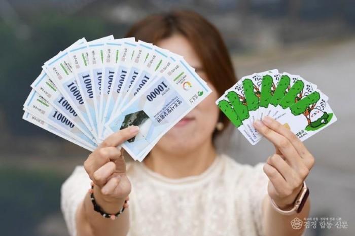 영주-2-1 영주시민이 영주사랑상품권과 영주사랑체크카드를 들어보이고 있다.JPG