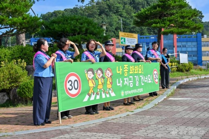 영주-6-2 영주녹색어머니연합회 회원들이 교통안전 현수막을 들고 있다.jpg
